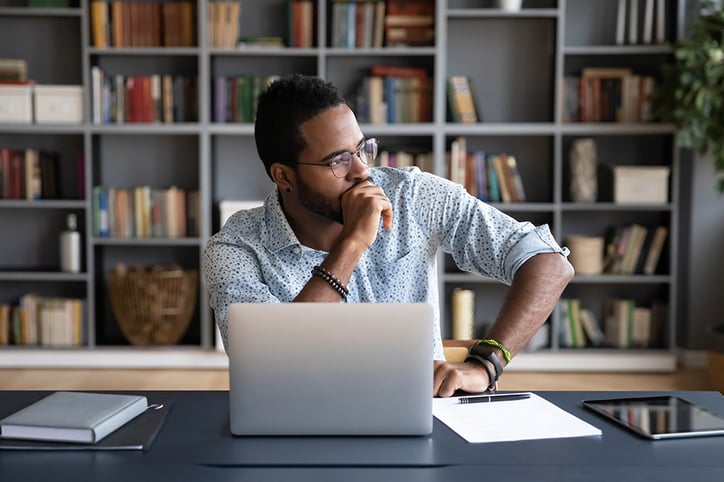 Man sitting at desk working on laptop