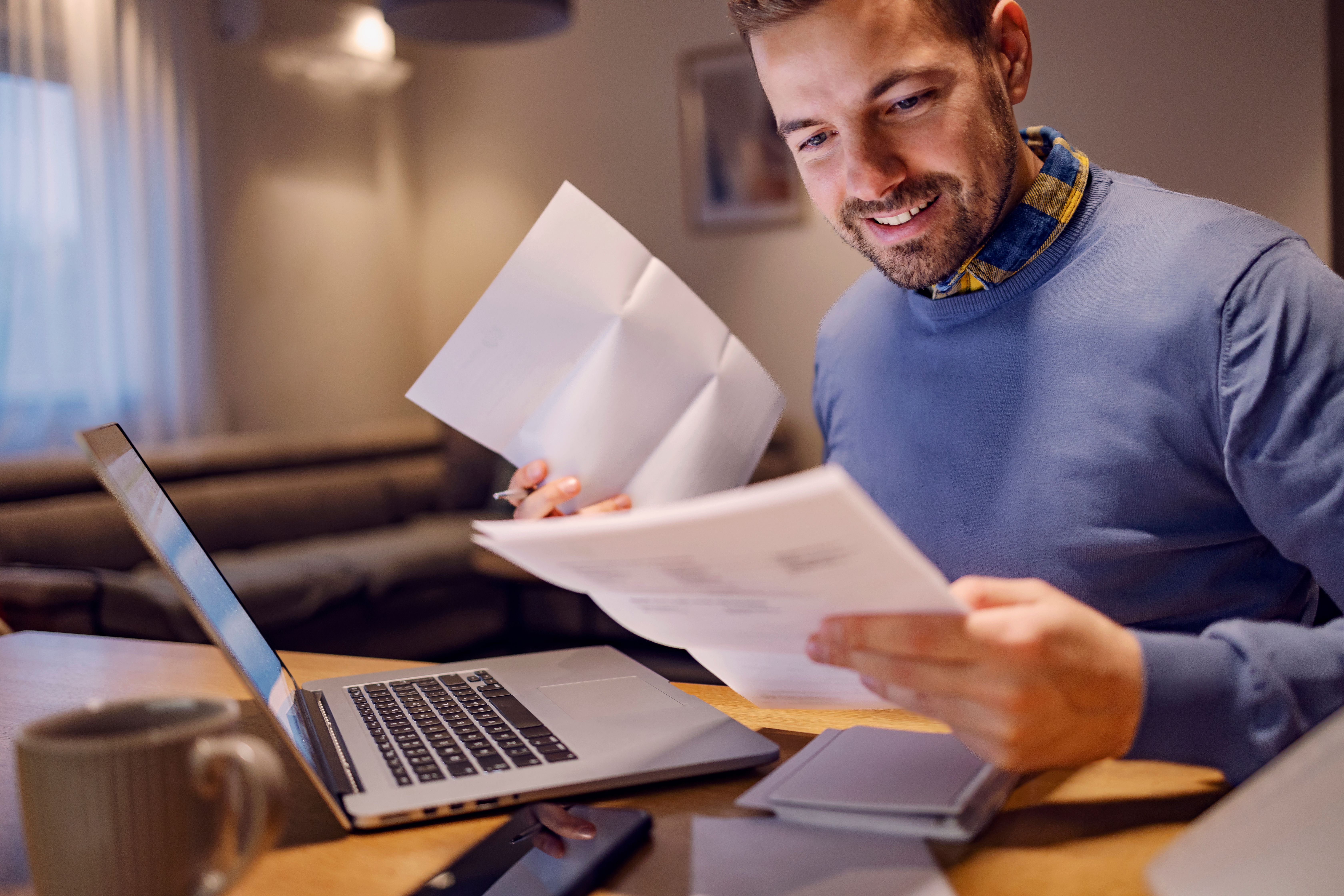 Image of a smiling man paying bills